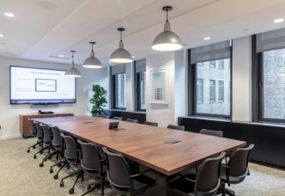 Large boardroom with a long wooden table and modern pendant lighting.