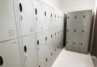 Rows of grey secure metal lockers in a clean, brightly lit hallway.