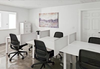 Open-plan workspace with white desks, black ergonomic chairs, and privacy dividers.
