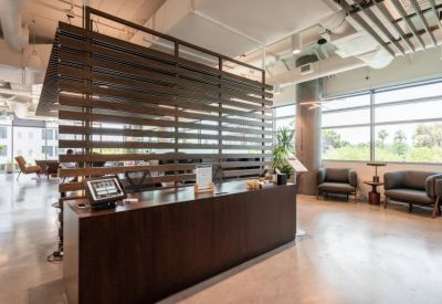 Professional wood-paneled reception desk with lounge seating and large windows.
