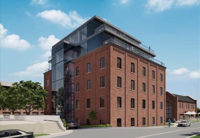 Rear exterior angle showing the modern glass elevator shaft and brick facade.