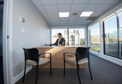 Private office with a light wood desk and large windows overlooking the city.