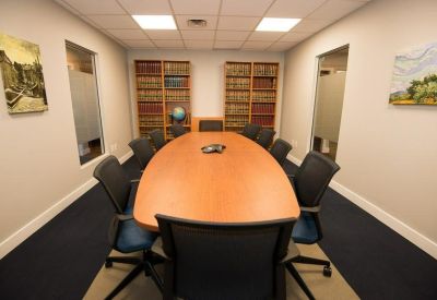 Formal boardroom with a large wooden table and built-in bookshelves.