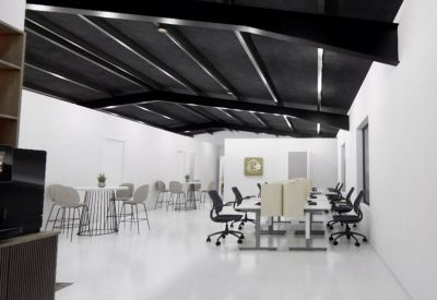 Spacious coworking area with multiple workstations and high-top tables.