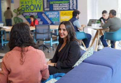 Vibrant coworking area with blue seating and motivational wall graphics.