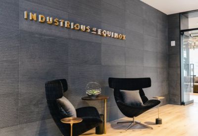 Branded reception area with stylish wingback chairs and wood flooring.
