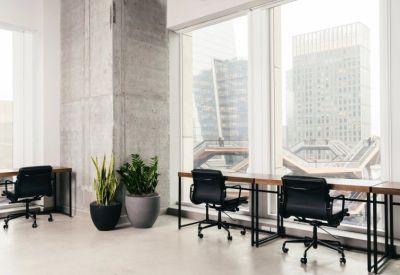 Bright coworking area with wood desks and views of the Vessel sculpture.