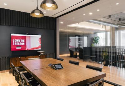 Modern conference room with a large wood table and digital presentation screen.