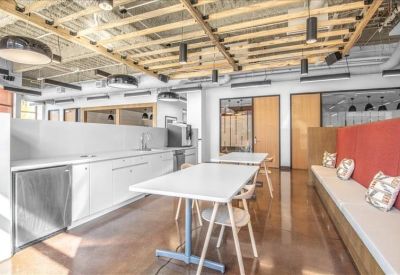Kitchen and breakout area with white cabinets and a long cushioned bench seat.