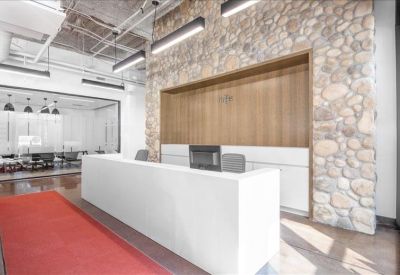 Minimalist reception area featuring a white desk and a textured stone feature wall.