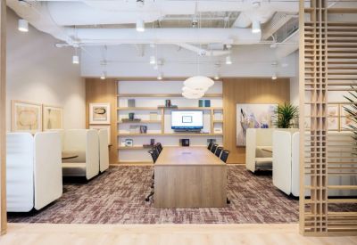 Spacious communal lounge and meeting area with high-backed booths and built-in wooden shelving.