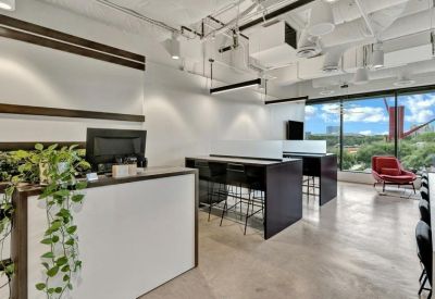 Bright reception desk with hanging greenery and industrial ceilings.