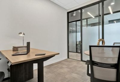 Private office suite with a wood-top desk and glass partitions.