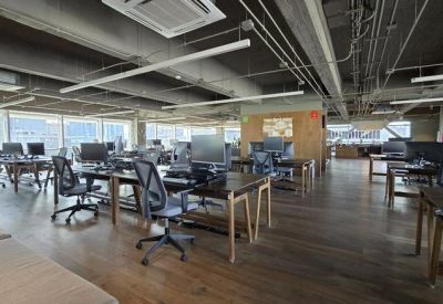 Open-plan workspace with multiple desks and office chairs.
