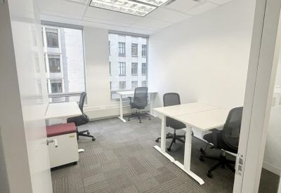 Private office suite with height-adjustable desks and large windows.