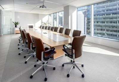 Large boardroom with a light wood table and floor-to-ceiling windows.