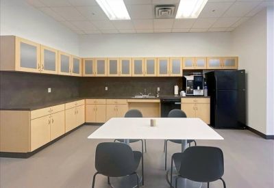 Bright communal kitchen area featuring black appliances and ample counter space.