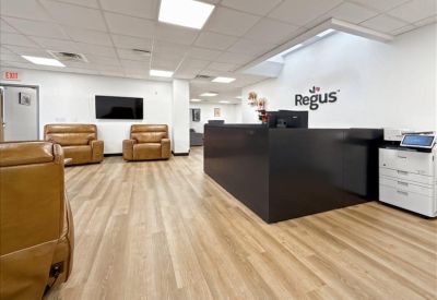 Branded reception area with leather armchairs and light wood flooring.