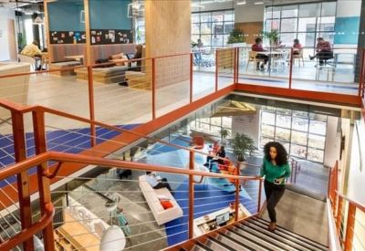 Multi-level workspace featuring a central staircase and upper-level meeting areas.