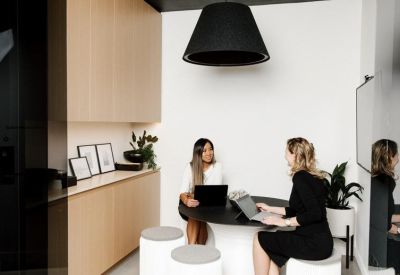 Minimalist boardroom with a long wooden table and views of the city mountains.