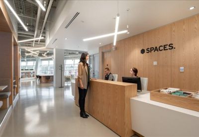 Bright reception area with a light wood desk and modern minimalist lighting.