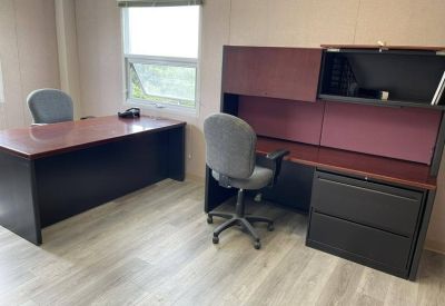 Two-person private office suite with dark wood desks and a window.