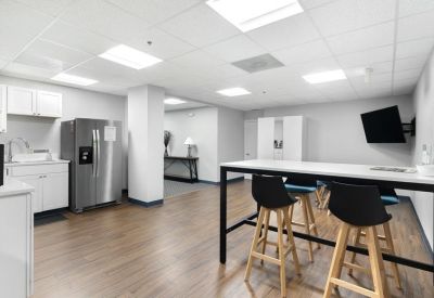 Modern lobby with a white reception desk and wood-look flooring.