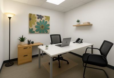 Private office with white desk, black chairs, and floral wall art.