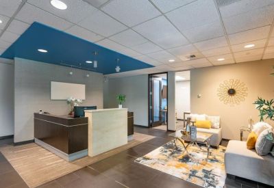 Professional reception desk with a dark wood finish and a blue recessed ceiling feature.