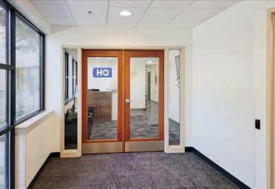 Office entryway featuring wooden double doors and glass panels.