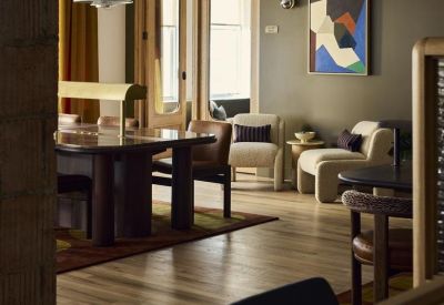 Reception or lounge entrance featuring olive green walls, wood floors, and designer light fixtures.