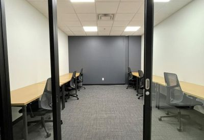 Interior private office with multiple workstations and a dark grey accent wall.