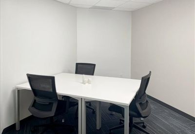 Small private office with a white table and two black mesh chairs.