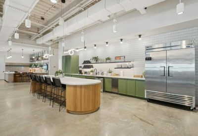Spacious communal kitchen with green cabinetry and a large wood-wrapped island.