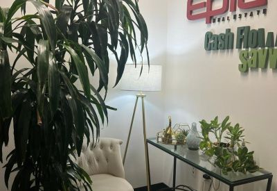 Reception area at 4245 South Grand Canyon Drive, Suite 224 featuring a tall plant, plush chair, and company logo.