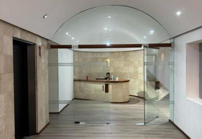Modern lobby area with a curved reception desk and polished wood-style flooring.