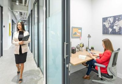 Modern private office suite with a glass door, wooden desk, and a world map wall hanging.