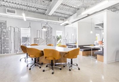 Large conference room with a city-themed mural and modern yellow chairs.