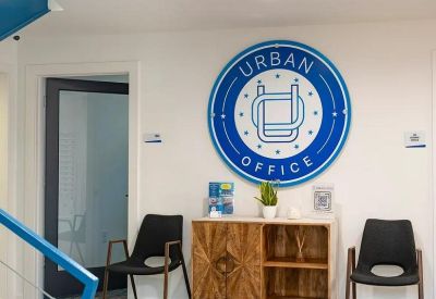 Bright reception area with blue branded logo on a white wall and modern wood cabinet.
