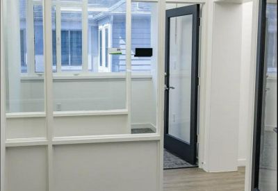 Modern private glass-partitioned office suite with natural light.