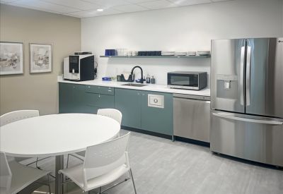 Communal kitchen area with sleek appliances and round dining table
