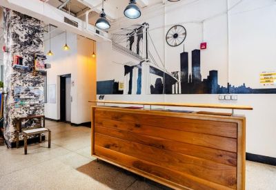 Wooden reception desk against a wall mural featuring the Brooklyn Bridge and NYC skyline.