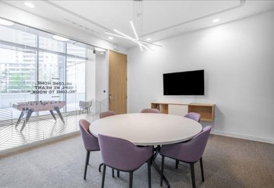 Private meeting room with a round table and purple chairs.