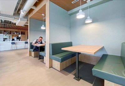 Modern breakout booths with teal seating and pendant lighting.