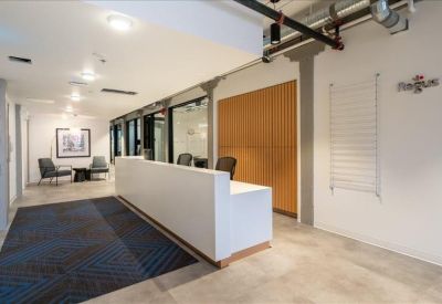 Professional reception area with a sleek white front desk and patterned blue rug.
