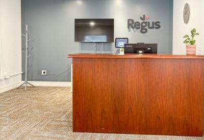 Branded reception area at 5360 Genesee Street, Suite 203, Bowmansville, New York with wooden desk and feature wall.