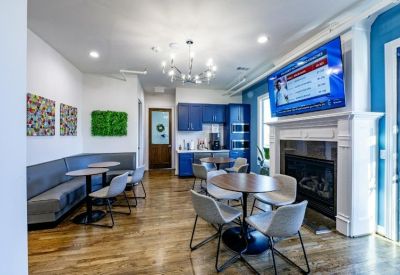 Communal break area featuring a white fireplace, blue cabinetry, and a wall-mounted TV.