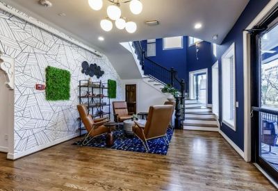 Reception lounge with blue accent walls, leather armchairs, and a stylish patterned feature wall.