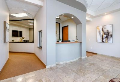 Reception area featuring a curved grey desk and an arched entryway.