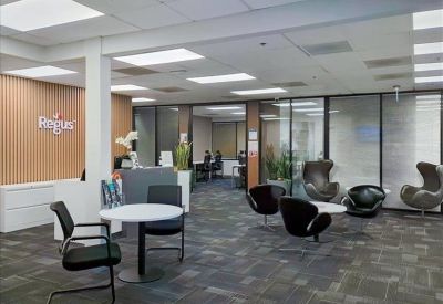 Spacious communal lounge with modern seating, wood-paneled walls, and reception desk.